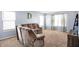 Cozy living room with plush carpeting, recliner seating, and large windows offering plenty of natural light at 16457 Anderson Way, Noblesville, IN 46062