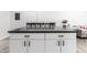 Close up of a kitchen island with white cabinets, black hardware, and a dark countertop with seating at 3144 Voigt Dr, Indianapolis, IN 46224
