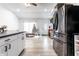 Modern kitchen flowing into a cozy living space with a Christmas tree, stainless appliances and dark countertops at 3144 Voigt Dr, Indianapolis, IN 46224