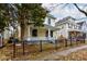 Two-story yellow house with a front porch and black fence at 317 N Arsenal Ave, Indianapolis, IN 46201