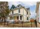Two story yellow house with a green roof at 317 N Arsenal Ave, Indianapolis, IN 46201