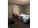Modest bedroom featuring a bed with blue patterned bedding and an exercise bike at 3306 N Drexel Ave, Indianapolis, IN 46218