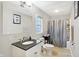 A bright bathroom featuring granite countertops, a large mirror, and a convenient shower-tub combination at 3933 Byram Ave, Indianapolis, IN 46208