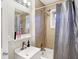 Bathroom featuring a shower-tub combo, vanity sink, and neutral tiling at 3933 Byram Ave, Indianapolis, IN 46208