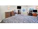 Comfortable bedroom with dressers, workspace, wall-mounted TV, and a queen bed at 3933 Byram Ave, Indianapolis, IN 46208