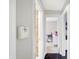 Hallway with neutral walls and a contrasting dark wood floor leads to rooms with distinct designs at 3933 Byram Ave, Indianapolis, IN 46208