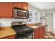 Bright kitchen showcasing modern gas range, stainless steel microwave and butcher block countertops at 3933 Byram Ave, Indianapolis, IN 46208