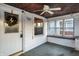 Bright, enclosed porch with rustic ceiling, windows overlooking neighborhood, and a view of front entry at 3933 Byram Ave, Indianapolis, IN 46208