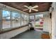 Enclosed sunroom featuring multiple windows that bring in ample light, rustic ceiling, and views of outdoors at 3933 Byram Ave, Indianapolis, IN 46208