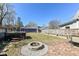 Backyard featuring a stone firepit area, a lush lawn, and a charming purple garage at 66 N Ritter Ave, Indianapolis, IN 46219