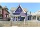 Quaint purple two-story home with a charming front porch and swing, set behind a picket fence at 66 N Ritter Ave, Indianapolis, IN 46219