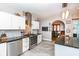 Open kitchen with stainless appliances, white cabinets, brick accent, and view into dining room at 66 N Ritter Ave, Indianapolis, IN 46219