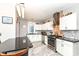Modern kitchen with white cabinets, stainless steel appliances, exposed brick, and black countertop island at 66 N Ritter Ave, Indianapolis, IN 46219