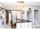 Stylish kitchen with stainless steel refrigerator, island seating, unique lighting, and view to the stairs at 66 N Ritter Ave, Indianapolis, IN 46219