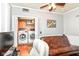 Cozy room with washer and dryer, a leather couch, and wall decor at 66 N Ritter Ave, Indianapolis, IN 46219