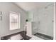 Modern bathroom with a glass-enclosed shower, black marble flooring, and vanity area, enhanced by natural light from a window at 8349 Tequista Cir, Indianapolis, IN 46236
