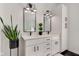 Bright bathroom featuring dual sinks, modern fixtures, and black marble accents, highlighted by stylish decor and ample lighting at 8349 Tequista Cir, Indianapolis, IN 46236