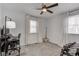 The bright bedroom includes a ceiling fan, two windows with curtains, and space for a desk and weights at 8349 Tequista Cir, Indianapolis, IN 46236