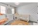Charming Bedroom with a crib, rocking chair, and decorative wall accents, creating a warm and inviting space for a baby at 8349 Tequista Cir, Indianapolis, IN 46236