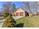 Detached two-car garage with a brown door, complemented by well-manicured landscaping and surrounding trees at 8349 Tequista Cir, Indianapolis, IN 46236
