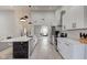 Modern kitchen features sleek white cabinets, black hardware, and a spacious island with a black marble accent, open to the living area at 8349 Tequista Cir, Indianapolis, IN 46236