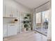 Bright kitchen featuring white cabinets, herringbone backsplash, and shelving with decorative items, near a sliding glass door to the deck at 8349 Tequista Cir, Indianapolis, IN 46236