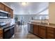 Modern kitchen with stainless steel appliances, wood cabinets, and an open layout to the dining area at 9703 W Stargazer Dr, Pendleton, IN 46064