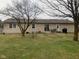 Spacious backyard with a lush lawn, a patio area with outdoor furniture, and mature trees providing shade at 971 Alexander St, Greenwood, IN 46143