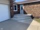 Inviting entrance with a brick facade, a white door, and newly built concrete steps at 971 Alexander St, Greenwood, IN 46143