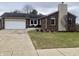 Charming brick home features an attached garage, a well-manicured lawn and concrete driveway at 971 Alexander St, Greenwood, IN 46143