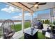 Covered patio with stylish seating, a fire table, and views of the landscaped backyard at 1006 Cherry Tree Ln, Greenwood, IN 46143