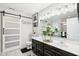 Bright bathroom with a dual sink vanity, barn door, decorative mirror, and modern lighting fixtures at 1006 Cherry Tree Ln, Greenwood, IN 46143
