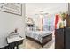 Well-lit bedroom with a ceiling fan, large window with red curtains, and study desk at 1006 Cherry Tree Ln, Greenwood, IN 46143