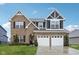 Charming two-story brick home with a two-car garage, manicured lawn, and beautiful architectural details at 1006 Cherry Tree Ln, Greenwood, IN 46143