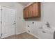 Practical laundry room features ample cabinet storage, utility sink, and direct access to the outdoors at 13998 Avalon Blvd, Fishers, IN 46037