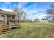 Wide backyard with green lawn, deck stairs, and screened porch at 1563 Old Thicket Ct, Greenwood, IN 46143