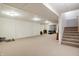 This is a large unfinished basement area featuring carpet, white painted walls, and an open stairwell at 1563 Old Thicket Ct, Greenwood, IN 46143