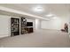 This basement area showcases a large space, a TV set and shelving, and it is well-lit with overhead lighting at 1563 Old Thicket Ct, Greenwood, IN 46143
