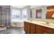 Bright bathroom with double sink vanity, soaking tub under two windows, and wood-look flooring at 1563 Old Thicket Ct, Greenwood, IN 46143