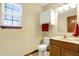 Well-lit bathroom features a wooden vanity, white toilet, cabinet, and a bright window at 1563 Old Thicket Ct, Greenwood, IN 46143