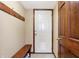 Entryway featuring a white front door, dark wood trim, and a wood bench with shoe storage at 1563 Old Thicket Ct, Greenwood, IN 46143