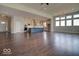 Open-concept living area with hardwood floors seamlessly connects the kitchen with stainless steel appliances and ample counter space at 15915 Bellows Dr, Fishers, IN 46040