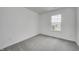 Neutral carpeted bedroom features a bright window, bringing in natural light and neighborhood views at 1934 Black Oak Dr, Shelbyville, IN 46176