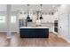 Stylish kitchen with white cabinets, black island, stainless appliances, and hardwood floors at 19997 Old Dock Rd, Westfield, IN 46074