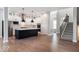 Open-concept kitchen with white cabinets, dark island, stainless appliances, and hardwood floors at 19997 Old Dock Rd, Westfield, IN 46074