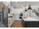 Modern kitchen with white cabinetry, quartz countertops, stainless steel appliances, and a large island at 19997 Old Dock Rd, Westfield, IN 46074
