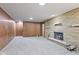 Finished basement featuring a brick fireplace, neutral carpet and accents, and wood-paneled walls at 2016 Colt Rd, Indianapolis, IN 46227