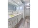 Bathroom with double sinks, wood-look tile floors, white tiling, and a combination shower and tub at 2016 Colt Rd, Indianapolis, IN 46227