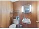 Small bathroom with wood-paneled walls, tiled floor, and updated sink, mirror, and fixtures at 2016 Colt Rd, Indianapolis, IN 46227