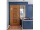 Inviting entryway with a wooden door, blue walls, and a colorful rug creating a warm welcome at 2016 Colt Rd, Indianapolis, IN 46227